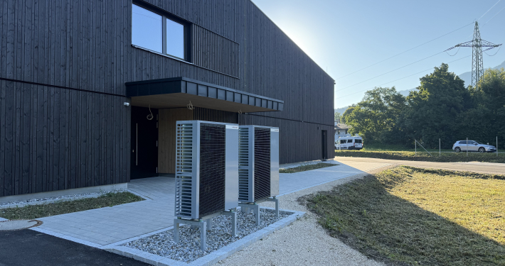 Moderne dunkle Gebäudefassade mit den Außeneinheiten der Weishaupt Wärmpepumpe